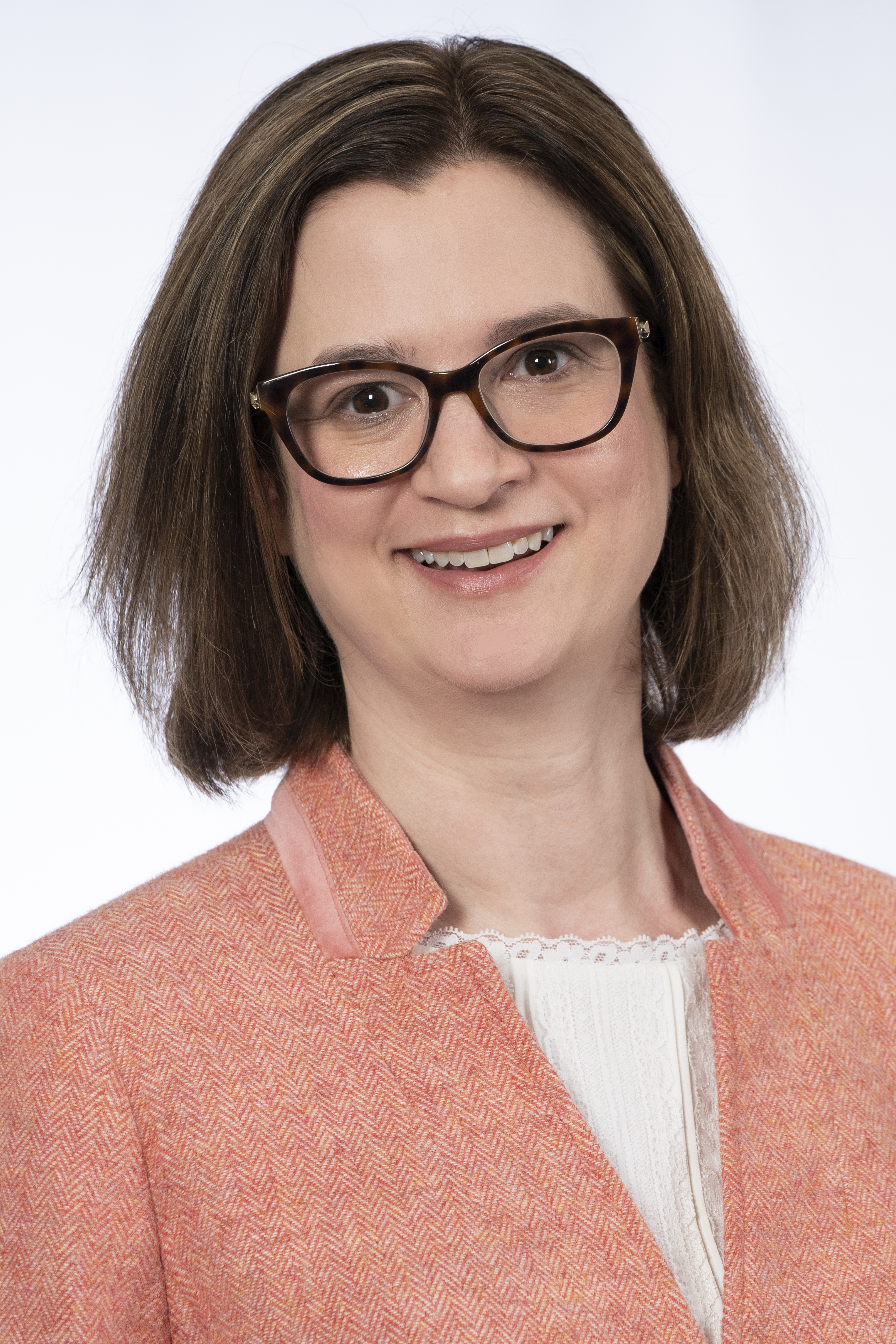 Amanda Ryan: women in glasses, white top and pink blazer